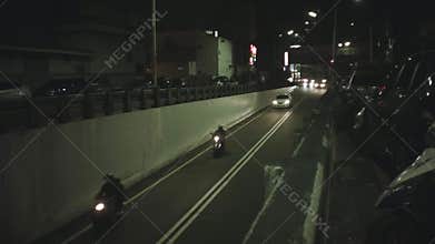 Still look down view of entrance of traffic tunnel with strong bring head light of vehicles cars and scooters motor bikes rushing