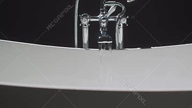 A woman is relaxing in a bathtub with a candle glowing in the background