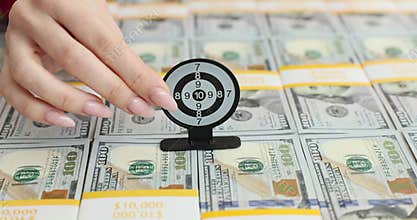 Target dart game on a stack of hundred dollar bills