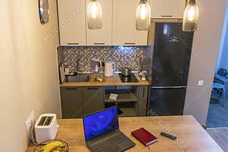 Laptop on the kitchen counter top with an excel sheet on computer screen showing bank loan amortization table. Finance