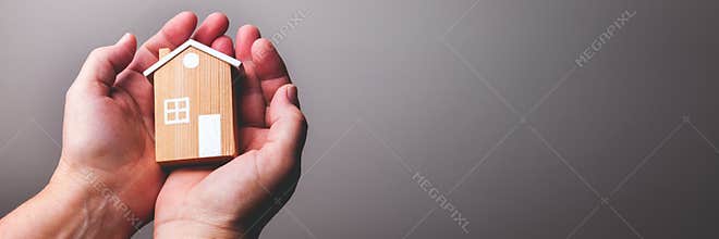 Hands Holding Little House Family Protection Concept