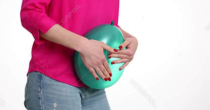Woman is holding large green balloon as sign of bloating
