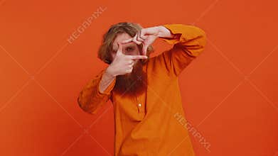 Man photographer gesturing picture frame with hands, looks through fingers focusing cropping image
