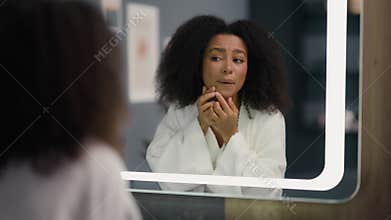 Frustrated African American girl woman female touch face bad condition complexion dermatology cosmetology looking in