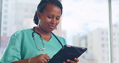 Smiling Doctor Using Tablet in Hospital Room