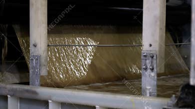 Pouring liquid pulp material into tank in plant workshop