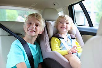 Brother and sister enjoying trip in the car
