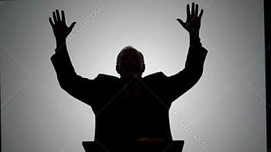 Man in Suit Raises Hands During a Presentation at Government Event
