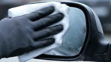 Wiping Water Droplets and Fog off a Car\'s Side View Mirror on a Cold Morning