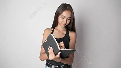 A woman is writing in a notebook