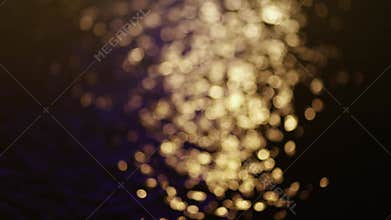 Golden bokeh shimmering on water surface at night, creating a warm and romantic atmosphere, calm emotional scenes, Perfect for