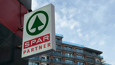 Retail store sign with spar branding outside urban building against clear sky