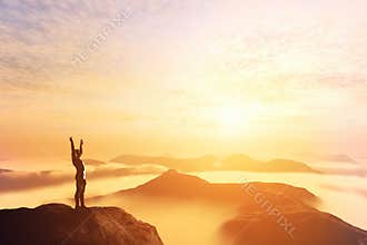 Happy man with hands up on the top of the world above clouds. Bright future