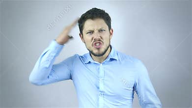 Portrait Of Angry Young Man Shouting Over Grey Background