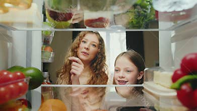 Woman and Girl at Kitchen Opening Fridge Door and Taking Healthy Food to Cook