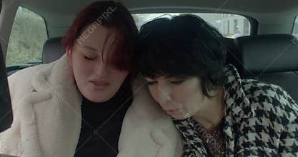 white bride-to-be and asian friend car rest leaning together prague