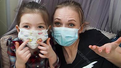 Mother and kid wearing medical mask talking about coronavirus. Home quarantine.