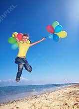 Child playing with balloons at the beach
