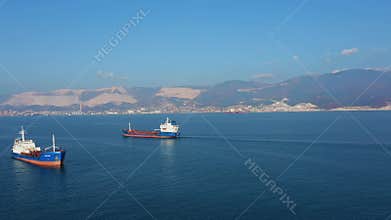 Aerial view of two large cargo ships leaving sea harbour at sunny day