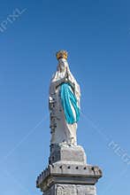 Virgin of Lourdes against the sky