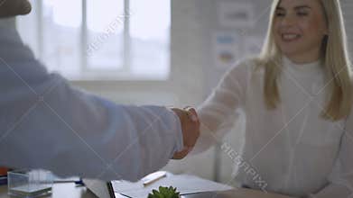 Young female job applicant or bank manager talking handshaking hr get hired at interview, happy businesswoman broker