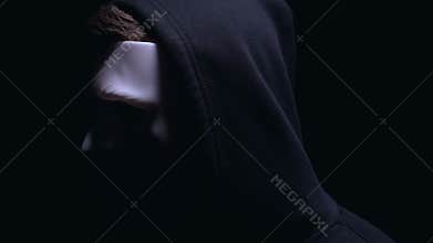 Hooded anonymous in mask turning face to camera, unrecognizable criminal