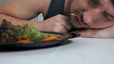 A bald fat vegetarian disgustingly eats salad. Proper nutrition, healthy lifestyle