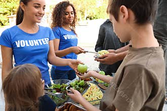 Volunteers serving food to poor people