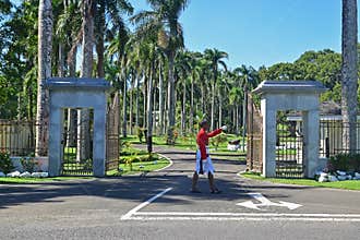 Guard marching in front of the Parliament House in Suva, Fiji with so much green and palm trees decorating the driveway