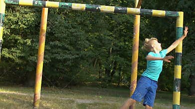 Boy playing football, trying to catch ball, summer free time, sport activity