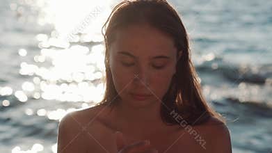 Woman is applying cream from sunburn on face skin