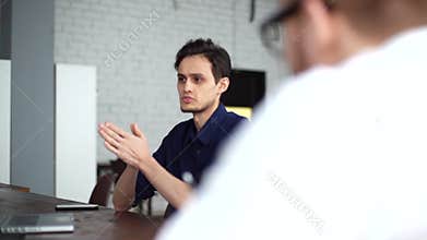 Confident young businessman presenting project to client in office meeting