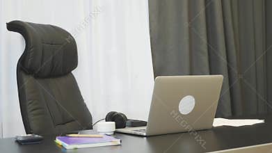 Empty working place with laptop and papers. Side view of workplace at empty office. Business concept