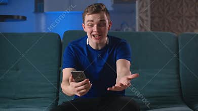 Young happy hockey fan winning a betting and watching a smart phone. Man celebrate win a bet with a gambling mobile app.