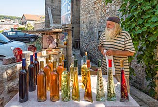 Local vendor selling homemade wine and liquor in Croatia, senior business