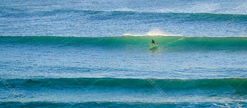 A man foil surfing on a backlit wave in imsouane,morocco