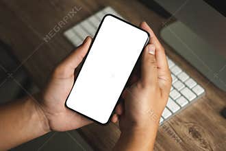 Top view Mockup image hand using a smartphone man Holding Cell Phone With Blank Screen
