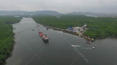 A drone flies along a large red cargo ship