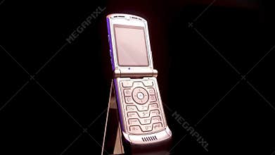 Spinning Motorola Razr V3 Opened Flip Cellular Mobile Phone on Black Background.
