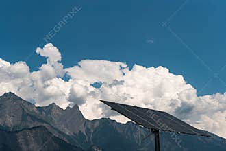 Large free-standing solar panel with mountain landscape in the Swiss Alps