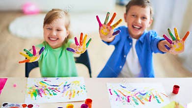Funny kids show their palms the painted paint. creative classes fine arts. two children a boy and a girl laugh. selective focusing