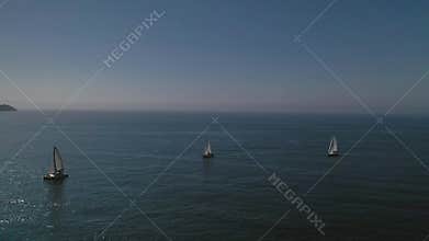 White sailing yachts in the blue sea top view from drone