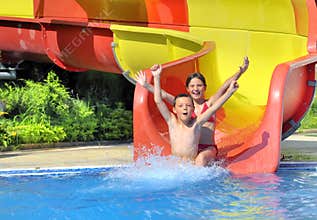 Children sliding down a water slide