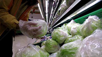 4K, Woman shopping a green lettuce at spanish supermarket. Vegetable food.