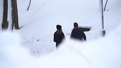 Man and woman in love walking in winter park covered with snow holding hands. Winter outdoor leisure of happy loving