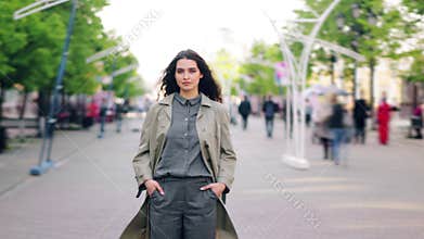 Time lapse portrait of young brunette standing in the street alone among crowd