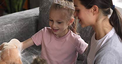 Pretty child girl wear crown playing puppet toy with mum