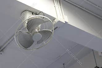 White fan mounted on the beam. Wall mounted fans mounted on top.