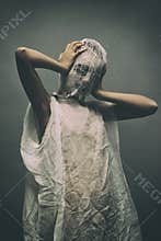 Scary Halloween. Horor. young girl in a strange suit. The face is covered with bound threads