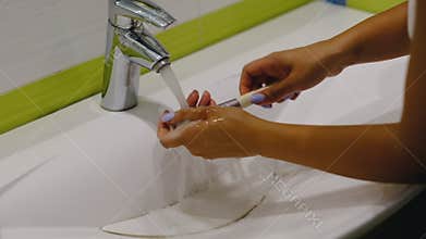 Slow motion. make up brush. Woman washing dirty makeup brush with soap and foam in the sink
